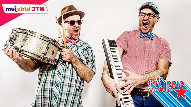 the two members of Sugar Free Allstars - the man on the left is holding a keyboard and smiling and the man on the right is holding up a drum and drum stick